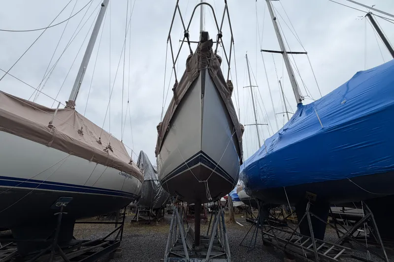 Slide: The Image of 1984 C&C 35-3 sailboat in dry dock, surrounded by covered boats. - 46