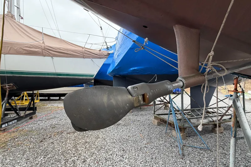 Slide: The Image of 1984 C&C 35-3 sailboat propeller and rudder, dry docked with other covered boats. - 48