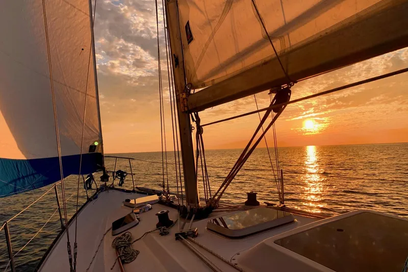 Slide: The Image of Sailing at sunset on a 1984 C&C 35-3 yacht, serene ocean view. - 6