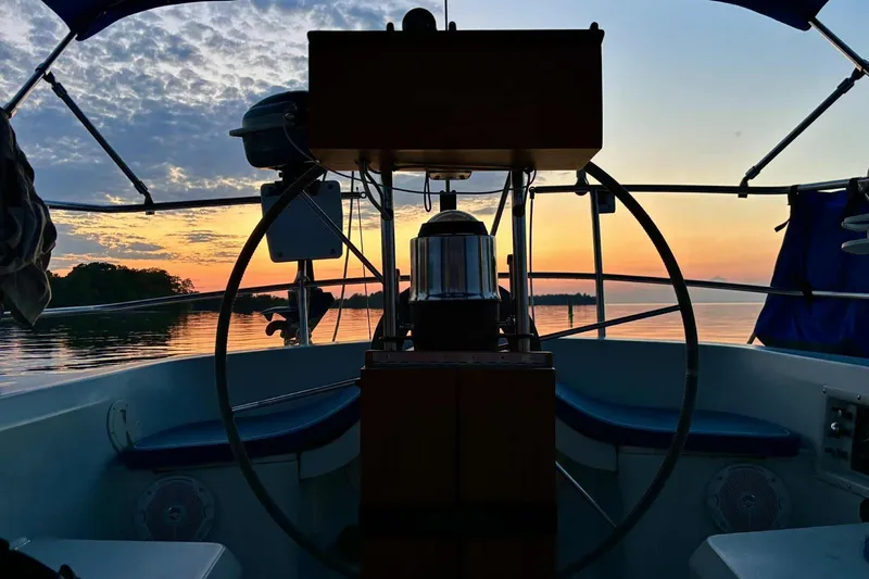 Slide: The Image of Cockpit view of 1984 C&C 35-3 sailboat at sunset on calm water. - 7