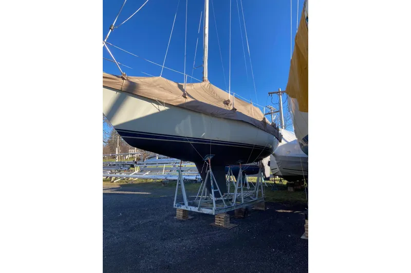Slide: The Image of 1984 C&C 35-3 sailboat on stands, covered, under clear blue sky. - 9