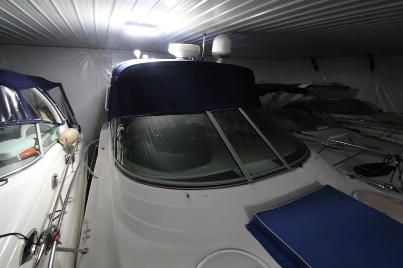Slide: The Image of 2007 Four Winns 378 Vista yacht stored indoors, featuring a sleek design and blue accents. - 19