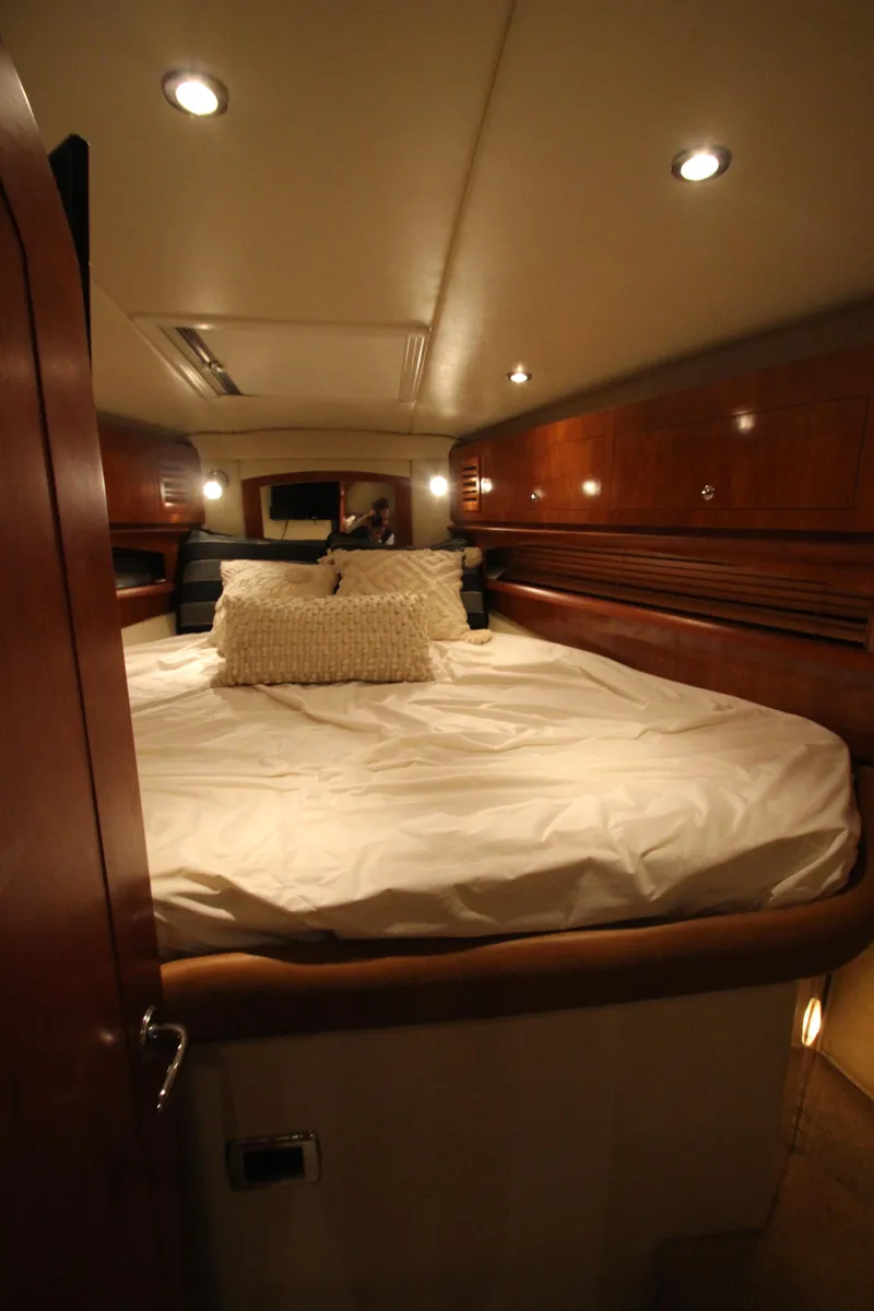 Slide: The Image of 2007 Four Winns 378 Vista cabin interior with cozy bed and warm lighting. - 34