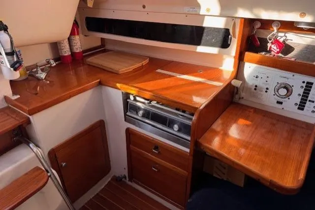 Slide: The Image of Cozy 1994 Catalina 270 yacht interior with wooden cabinetry and navigation equipment. - 11