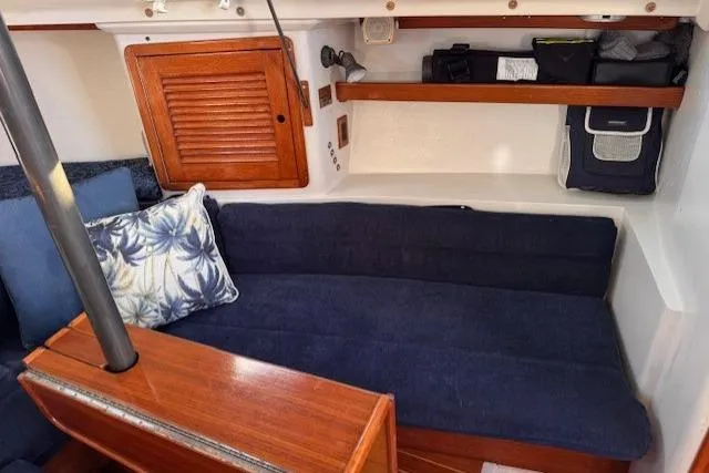 Slide: The Image of Interior of a 1994 Catalina 270 sailboat with blue cushions and wooden accents. - 13