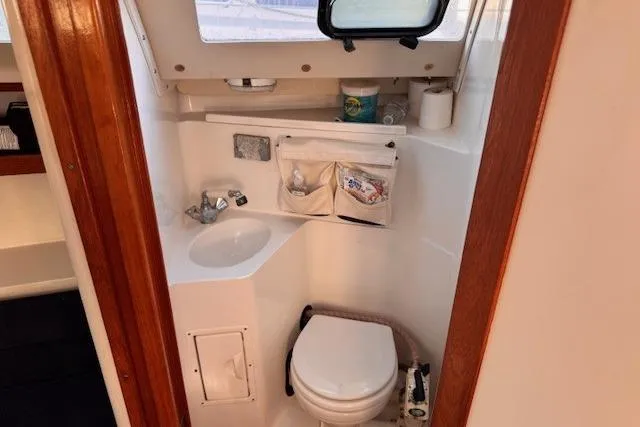Slide: The Image of Compact bathroom in a 1994 Catalina 270 sailboat, featuring a sink and toilet. - 16