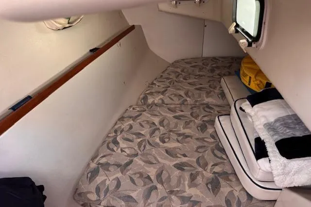 Slide: The Image of Cozy cabin interior of a 1994 Catalina 270 sailboat with patterned bedding and storage. - 17