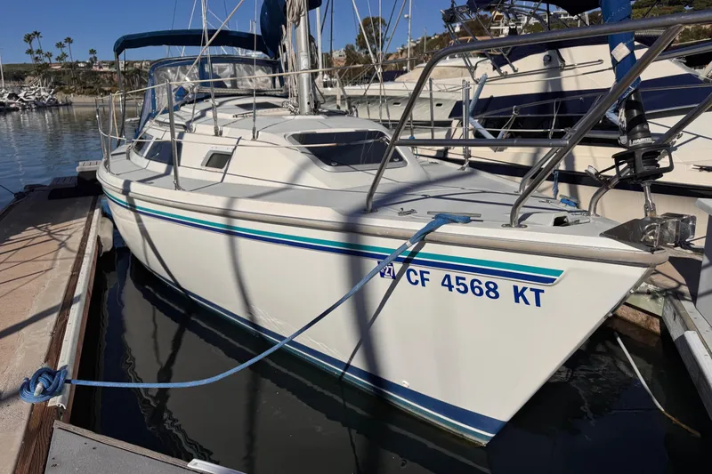 Slide: The Image of 1994 Catalina 270 sailboat docked at marina, featuring sleek design and blue accents. - 2