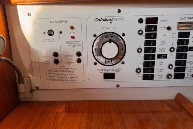 Slide: The Image of Control panel of a 1994 Catalina 270 yacht, featuring AC and DC service switches. - 23