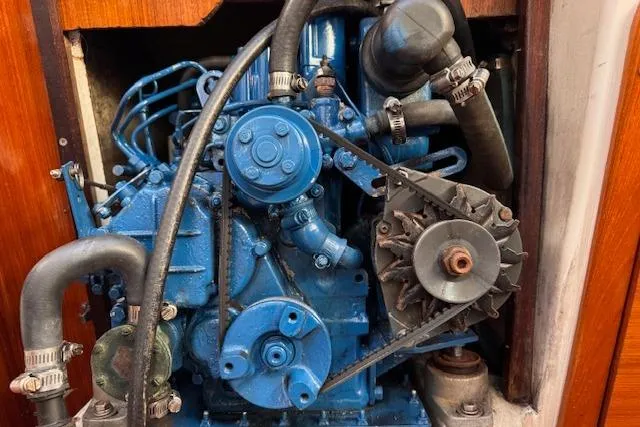 Slide: The Image of 1994 Catalina 270 engine, blue components, detailed view, wooden panel background. - 24