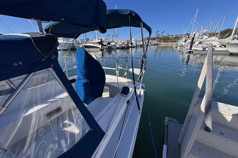 Slide: The Image of 1994 Catalina 270 sailboat docked in a marina, featuring blue canvas covers. - 3