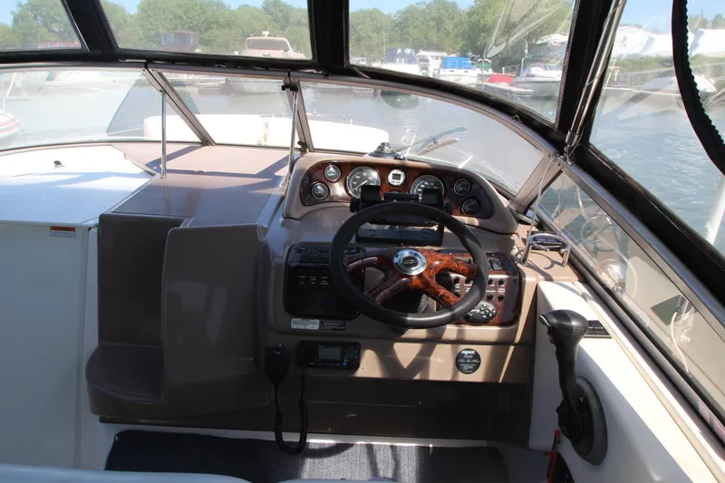 Slide: The Image of 2004 Regal 2665 Commodore boat cockpit with steering wheel and control panel. - 11