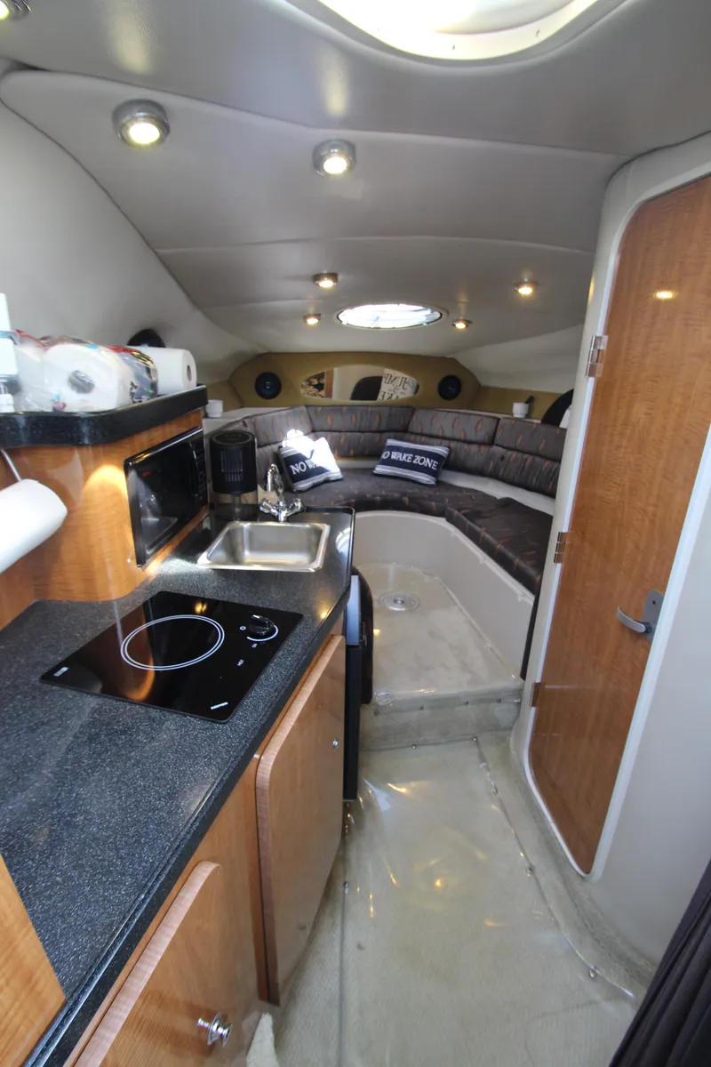 Slide: The Image of 2004 Regal 2665 Commodore cabin interior with kitchenette and seating area. - 15