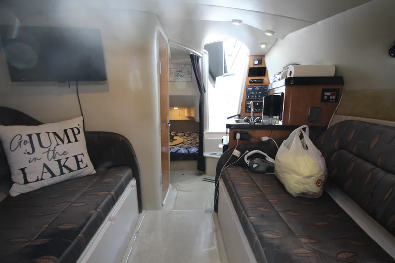 Slide: The Image of Interior of 2004 Regal 2665 Commodore boat with seating, TV, and kitchenette. - 20