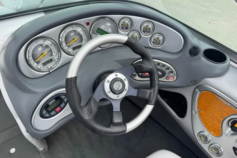 Slide: The Image of 2004 Correct Craft Air Nautique 216 Limited dashboard with steering wheel and gauges. - 16