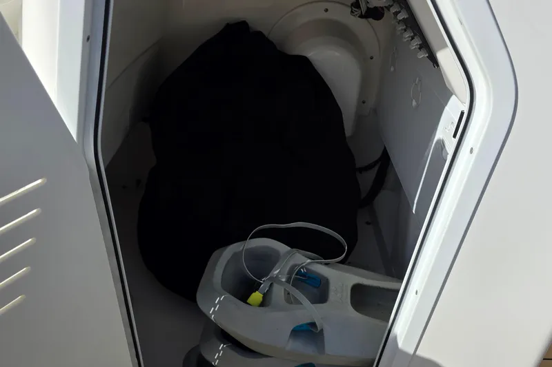 Slide: The Image of Storage compartment inside 2018 Everglades 243 Center Console boat, featuring equipment and gear. - 15