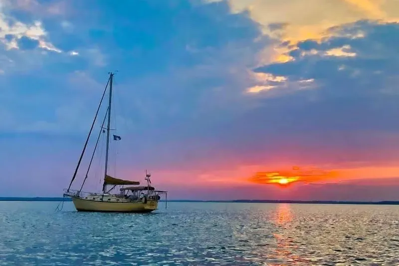 The Image of Sailboat Island Packet 35, 1991, anchored at sunset on tranquil waters. - 0