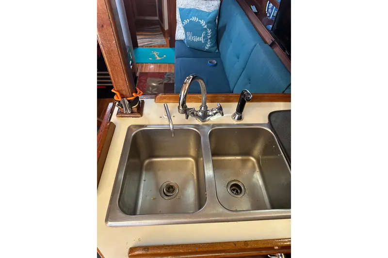 Slide: The Image of 1991 Island Packet 35 yacht kitchen with double sink and cozy seating area. - 19