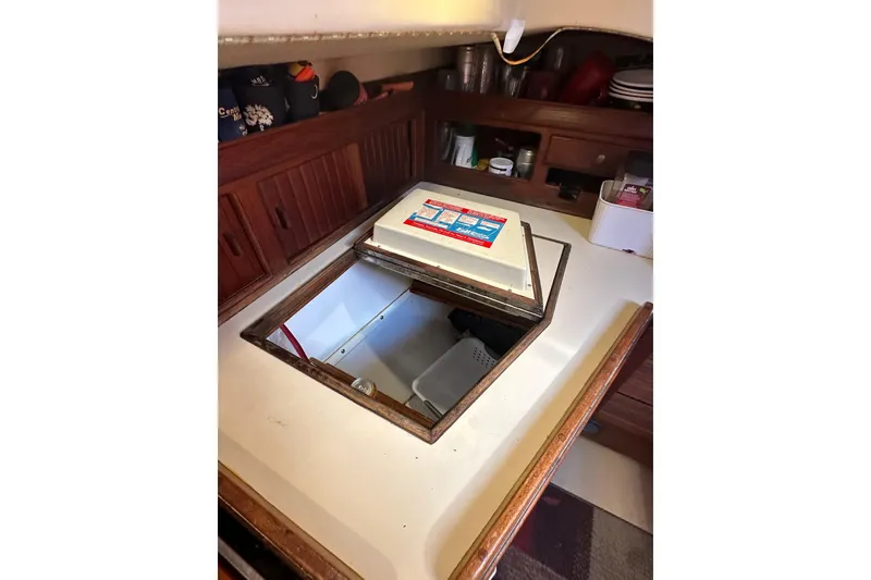 Slide: The Image of Interior of 1991 Island Packet 35 sailboat with open storage compartment in the galley. - 20
