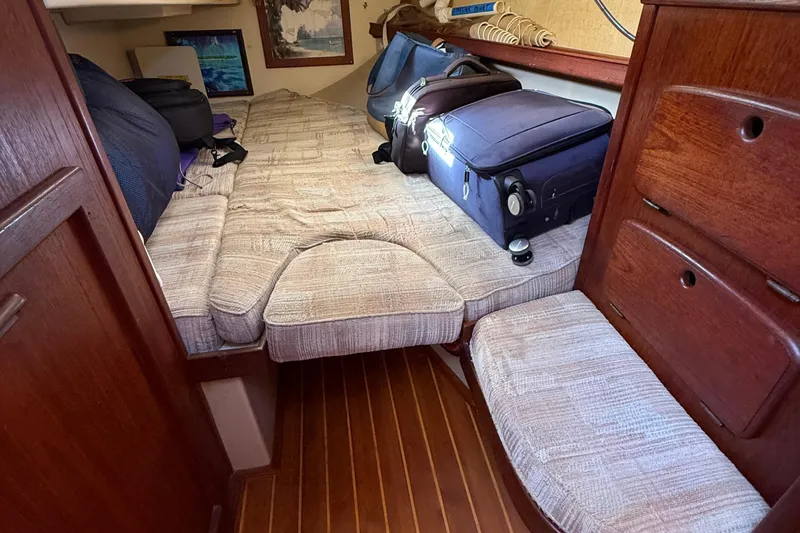 Slide: The Image of 1991 Island Packet 35 cabin interior with luggage and wooden furnishings. - 33