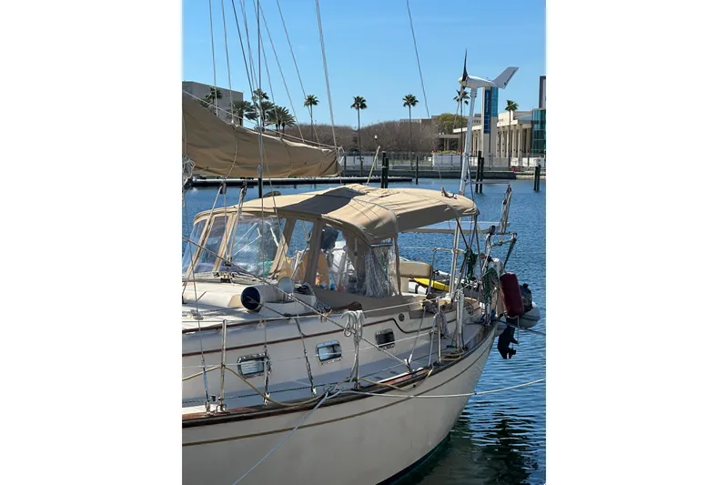Slide: The Image of 1991 Island Packet 35 sailboat docked in sunny marina with palm trees. - 39