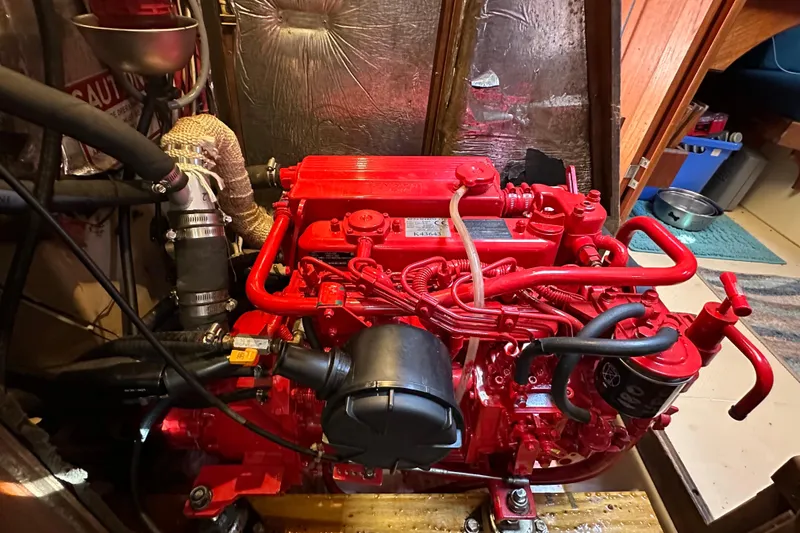 Slide: The Image of Red engine inside a 1991 Island Packet 35 sailboat, showcasing detailed components. - 40