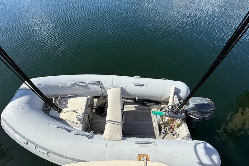 Slide: The Image of Inflatable dinghy with outboard motor on water, viewed from Island Packet 35, 1991. - 41