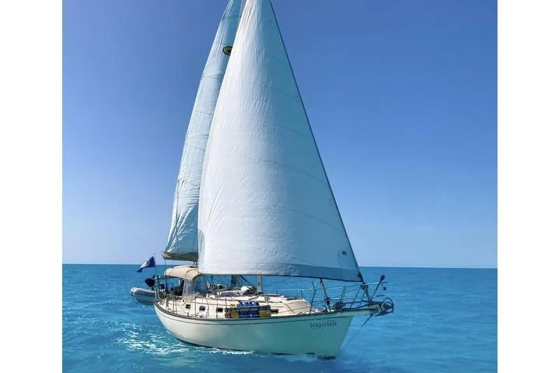 Slide: The Image of 1991 Island Packet 35 sailboat cruising on clear blue ocean waters. - 42