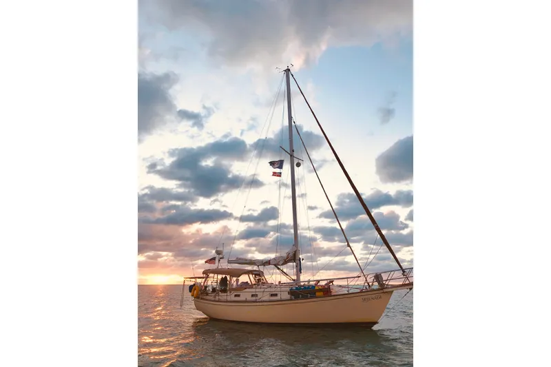 Slide: The Image of Sailboat Island Packet 35, 1991 model, on calm sea at sunset with cloudy sky. - 44
