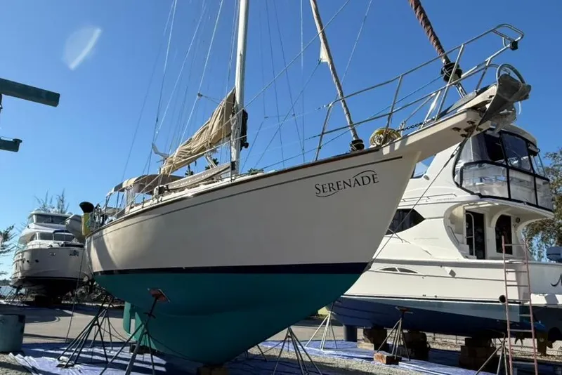 Slide: The Image of 1991 Island Packet 35 sailboat "Serenade" on dry dock, with clear blue sky background. - 48