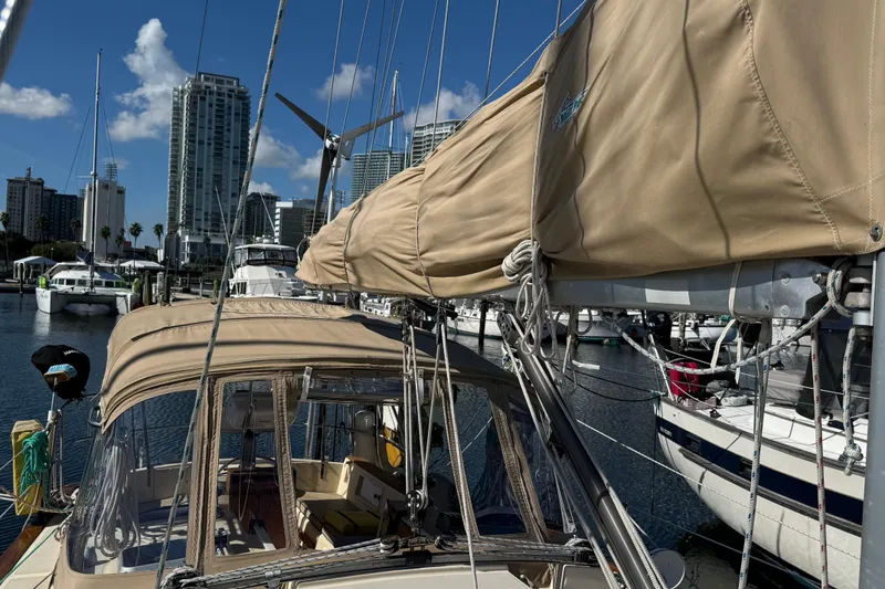 Slide: The Image of 1991 Island Packet 35 sailboat docked in a marina with city skyline backdrop. - 8