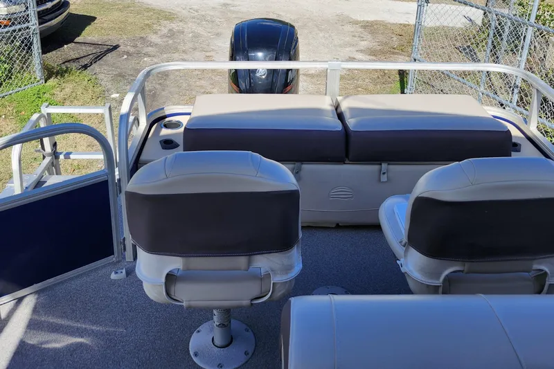 Slide: The Image of 2018 Sun Tracker Fishin' Barge 22 DLX interior with seating and motor view. - 13