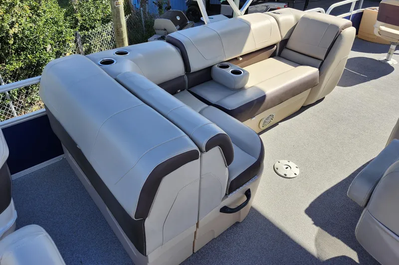 Slide: The Image of 2018 Sun Tracker Fishin' Barge 22 DLX interior with beige seating and cup holders. - 19
