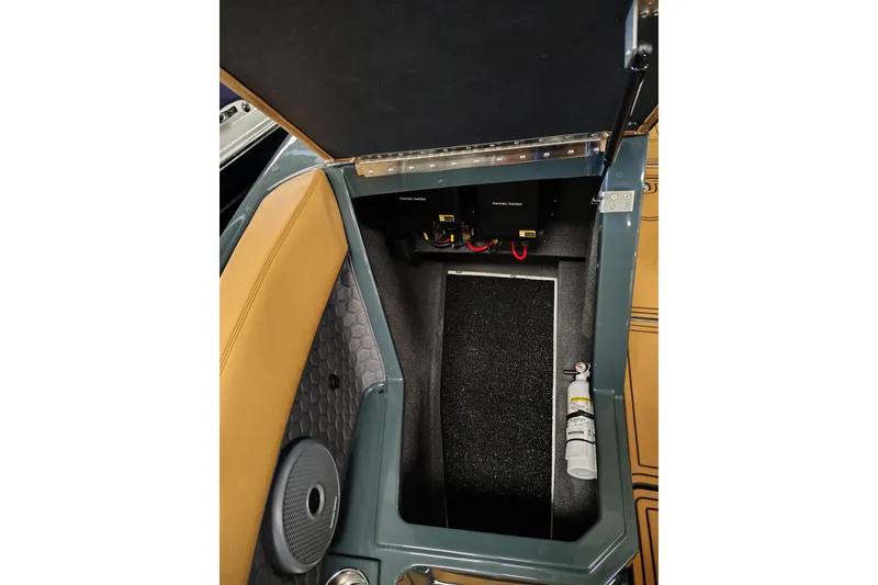 Slide: The Image of 2026 Cobalt R8 Surf boat storage compartment with premium audio system and fire extinguisher. - 7