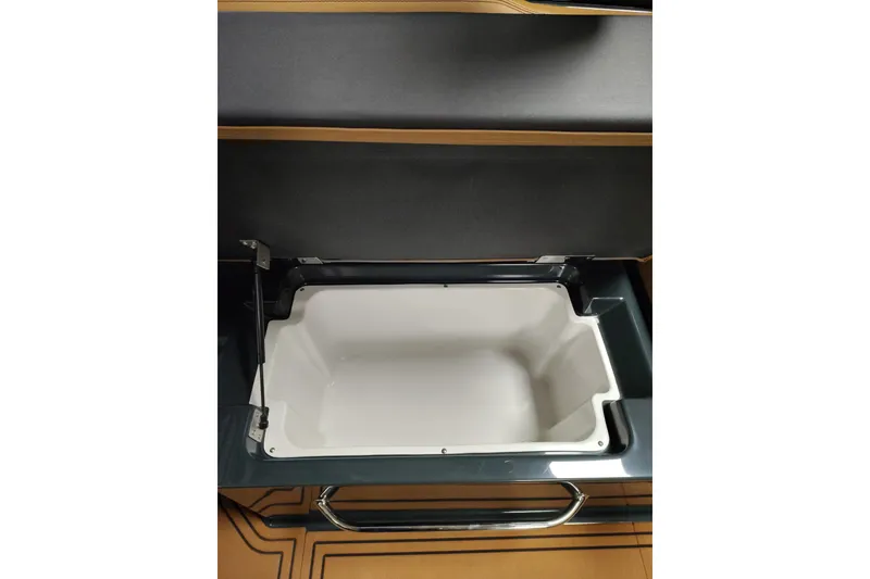 Slide: The Image of 2026 Cobalt R8 Surf boat storage compartment with open lid, showcasing interior space. - 9
