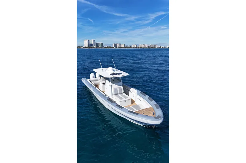 Slide: The Image of Ocean 1 370 boat, 2022 model, cruising on blue ocean with city skyline in background. - 6