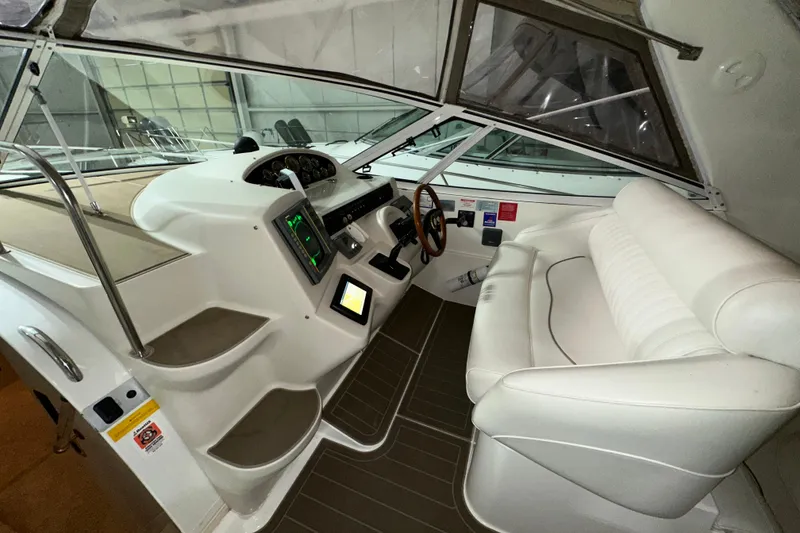 Slide: The Image of 1999 Cruisers Yachts 3870 Esprit helm with white seating and modern controls. - 10