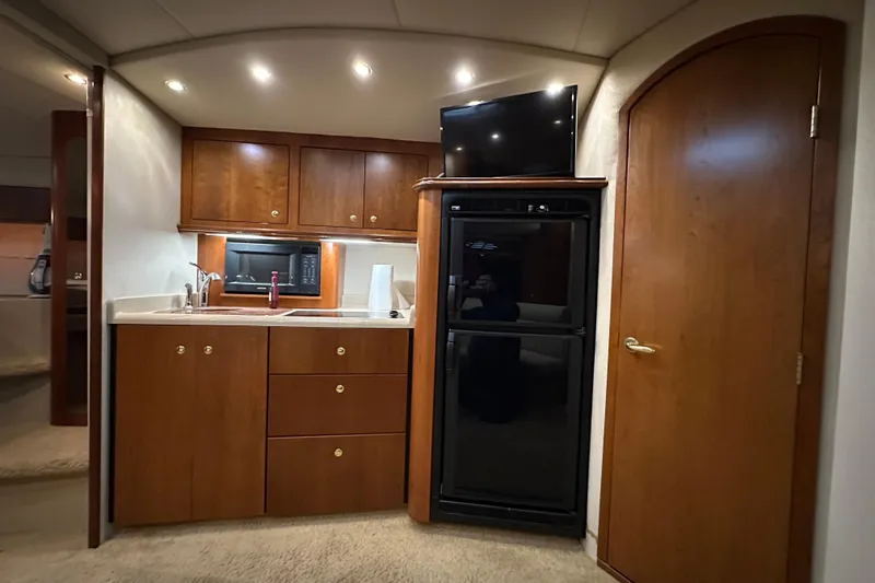 Slide: The Image of 1999 Cruisers Yachts 3870 Esprit interior kitchen with wood cabinets, fridge, and microwave. - 15