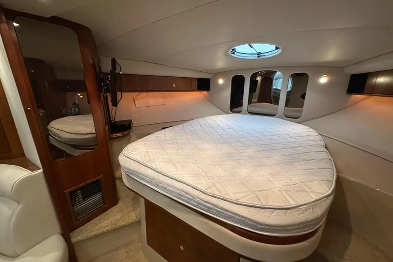 Slide: The Image of 1999 Cruisers Yachts 3870 Esprit cabin interior with bed, mirrors, and wood accents. - 18