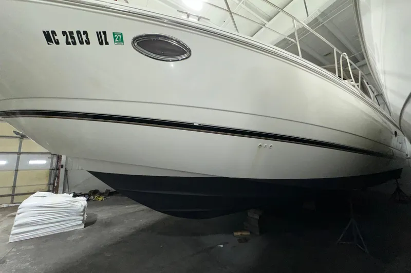 Slide: The Image of 1999 Cruisers Yachts 3870 Esprit in storage, side view of hull and registration. - 26