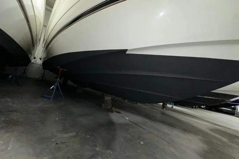 Slide: The Image of 1999 Cruisers Yachts 3870 Esprit boat hull in storage, supported by stands. - 27