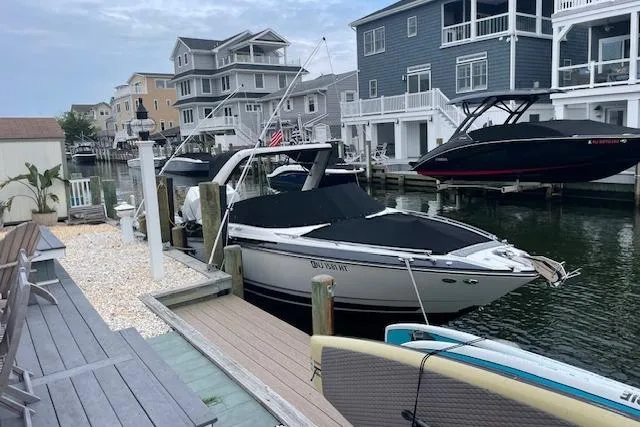 Slide: The Image of 2021 Monterey 305SS Super Sport boat docked by waterfront homes. - 2