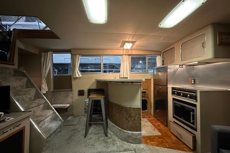 Slide: The Image of 1986 Chris-Craft 381 Catalina interior with kitchen, bar, and stairs, featuring modern amenities. - 12