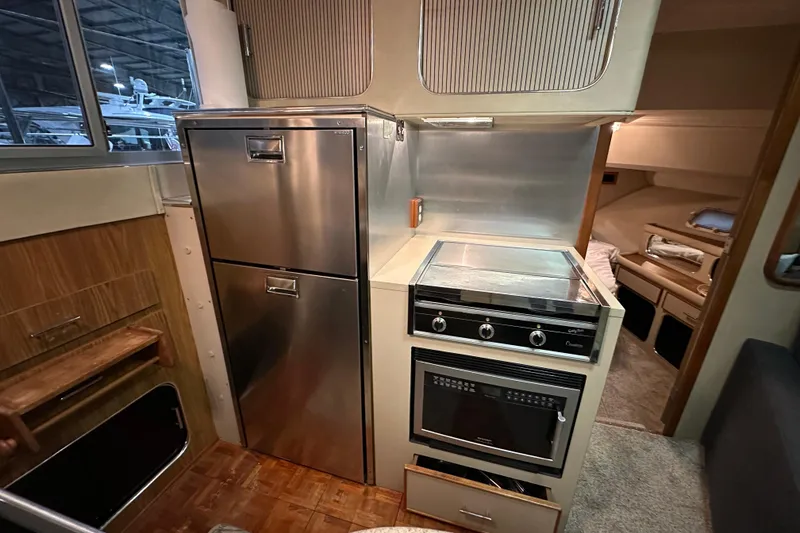 Slide: The Image of 1986 Chris-Craft 381 Catalina yacht interior kitchen with stove, oven, and stainless steel fridge. - 13