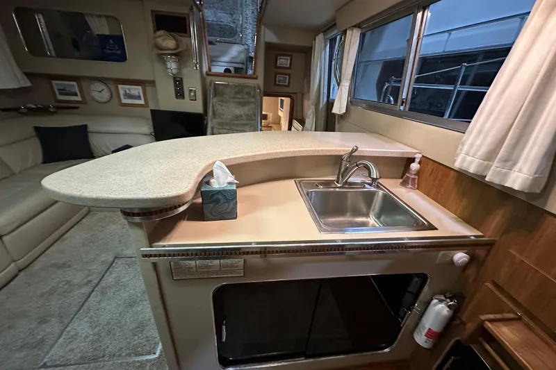 Slide: The Image of 1986 Chris-Craft 381 Catalina interior with kitchenette, sink, and seating area. - 14
