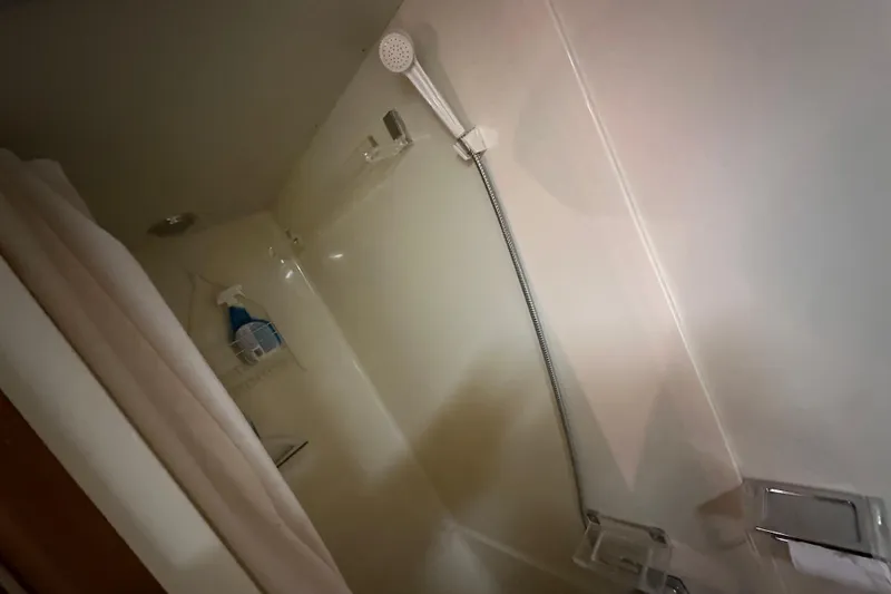 Slide: The Image of Shower area inside 1986 Chris-Craft 381 Catalina boat, featuring a handheld showerhead. - 19