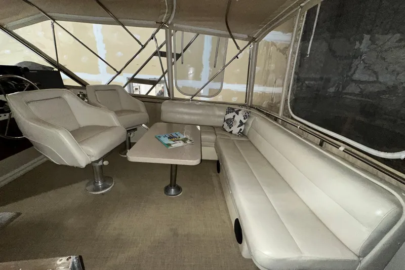 Slide: The Image of 1986 Chris-Craft 381 Catalina interior with beige seating and table, showcasing spacious design. - 7