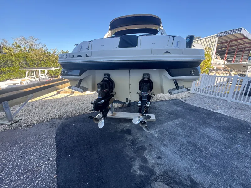 Slide: The Image of Rear view of a 2002 Sea Ray 290 Bowrider boat in a parking area. - 5