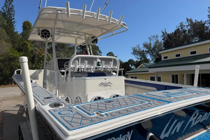 Slide: The Image of 2004 Jupiter 31 Cuddy boat with custom deck, docked near yellow building. - 18
