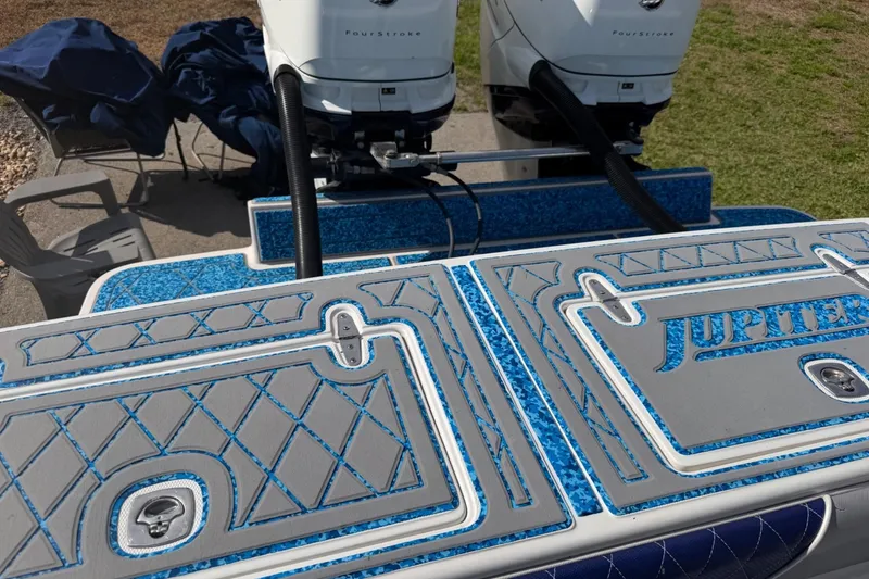 Slide: The Image of 2004 Jupiter 31 Cuddy boat deck with custom blue and gray design, featuring twin FourStroke engines. - 19